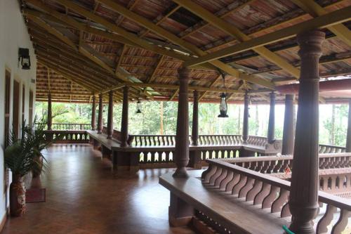 a pavilion with benches and a wooden ceiling at Wayal Wayanad Twin Villa in Panamaram
