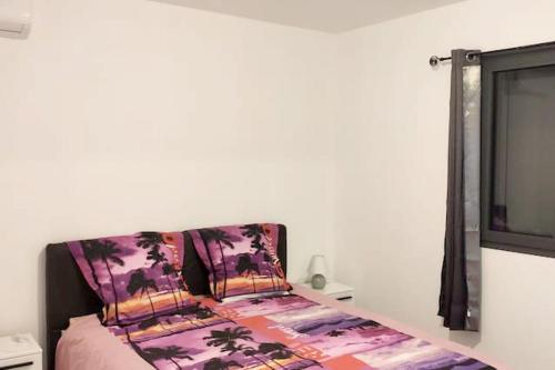 Un dormitorio con una cama y un televisor. en Appartement charmant à Saint Pierre 44 m² avec jardin clôturé, en Saint-Pierre