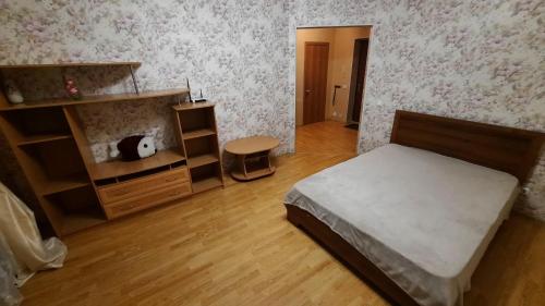 a bedroom with a bed and a wooden floor at комфортная 2 комнатная квартира возле Аквапарка на Комсомольской 148 in Ufa