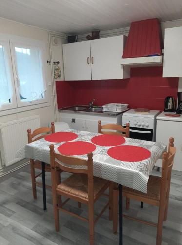 une cuisine avec une table et des plaques rouges. dans l'établissement Le Mélusine, à Gérardmer