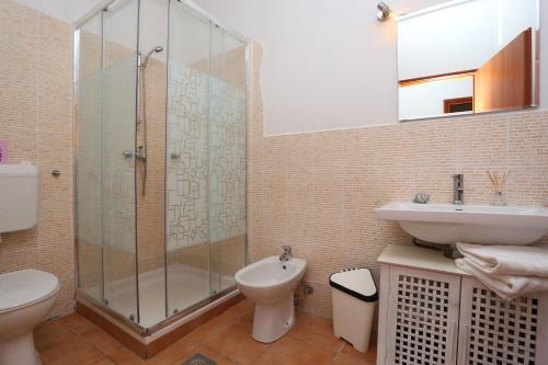 a bathroom with a shower and a toilet and a sink at Charming villa with private pool near the sea and garden in Ripenda Kras
