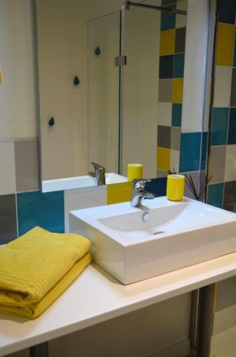 une salle de bain avec un lavabo blanc et un miroir dans l'établissement Maison charmante avec vue sur la mer à Locquirec, à Locquirec