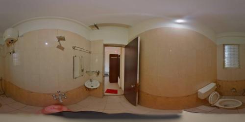 a large bathroom with a toilet and a sink at Sorrento Homes in Pune