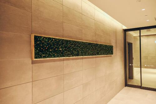 a wall with a plant on it in a bathroom at Nikko Style Nagoya in Nagoya