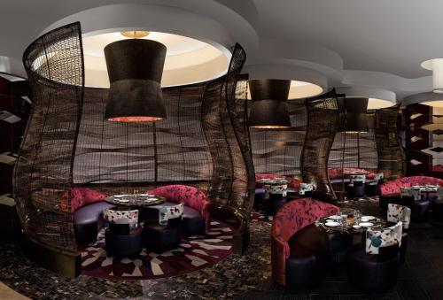 a restaurant with black tables and red chairs at Nobu Las Vegas, A Caesars Destination in Las Vegas