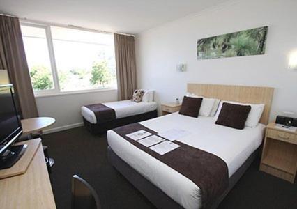 a hotel room with two beds and a television at Comfort Inn Capital Horsham in Horsham