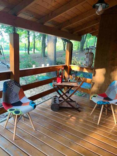 two chairs and a table on the porch of a cabin at Cozy Chalet in Castell'Arquato 90 m² with Private Pool in CastellʼArquato