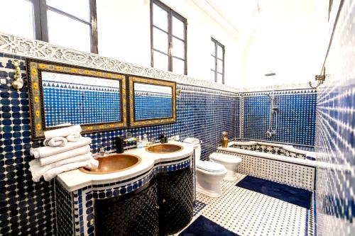 y baño con lavabo, aseo y azulejos azules. en 3 bedrooms apartement with private pool enclosed garden and wifi at Fes en Fez
