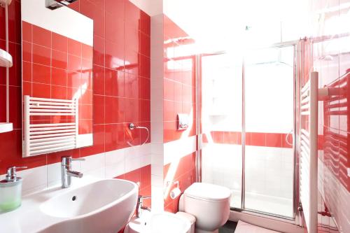 bagno rosso con lavandino e servizi igienici di Studio with wifi at Nicolosi a Nicolosi