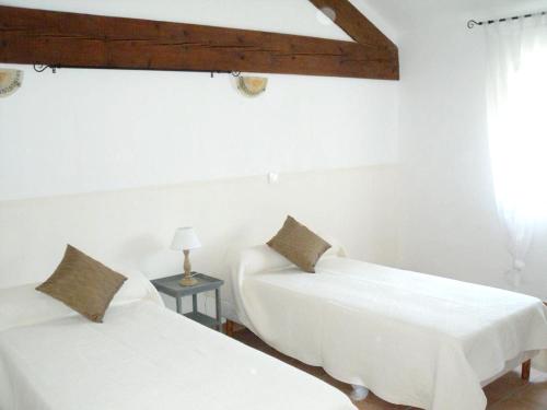 2 camas en una habitación con paredes blancas en Maison de 2 chambres avec piscine partagee jardin clos et wifi a Monteux, en Monteux