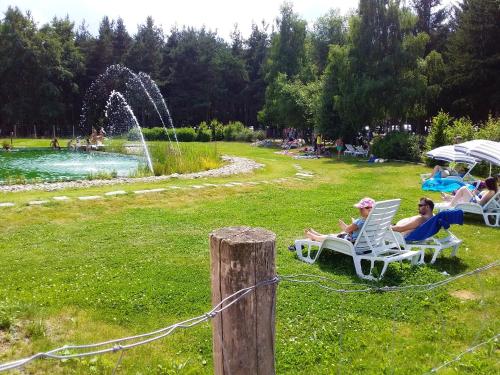 a group of people sitting in lawn chairs near a fountain at Maison de charme avec jardin à Cubelles, idéale en famille in Cubelles