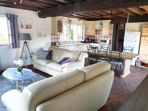 un salon avec deux canapés et une cuisine dans l'établissement Maison accueillante à Salbris avec jardin clos et terrasse., à Salbris