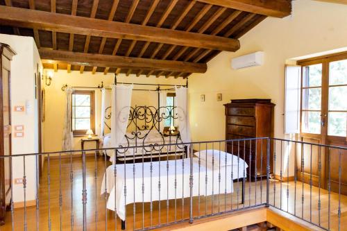 um quarto com uma cama de ferro forjado num quarto em 4 bedrooms house with shared pool furnished garden and wifi at Ramazzano Le Pulci em Ramazzano