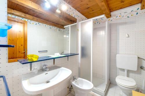 a bathroom with a toilet and a sink and a shower at Spacious Apartment in San Teodoro with Garden and Parking in San Teodoro