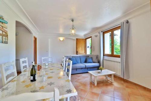 un salon avec une table et un canapé bleu dans l'établissement Appartement confortable au Bar-sur-Loup 60 m² avec jardin, à Le Bar-sur-Loup