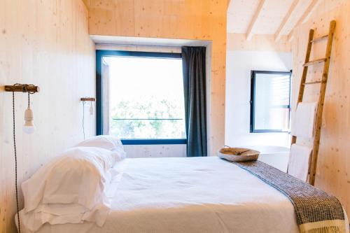 a bedroom with a white bed and a window at Elegant Apartment Alvados 50m² + Pool in Alvados