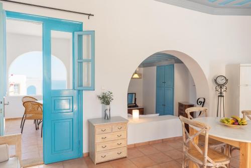 a kitchen and dining room with blue doors and a table at Patmos Studios in Skala