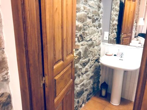 a bathroom with a wooden door and a sink at Spacious House in Molinaseca with Mountain View in Molinaseca