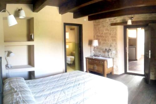 1 dormitorio con 1 cama y puerta al baño en One bedroom appartement with shared pool and wifi at Montalto delle Marche en Montalto delle Marche