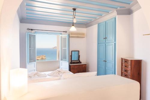 a bedroom with two beds and a view of the ocean at Patmos Studios in Skala