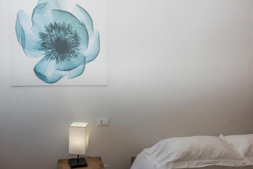 a bedroom with a blue flower painting on the wall at Luxury Seaview Apartments Manarola by Arbaspàa in Manarola