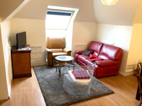 sala de estar con sofá rojo y TV en Appartement de 3 chambres avec jardin clos et wifi a Sannois, en Sannois