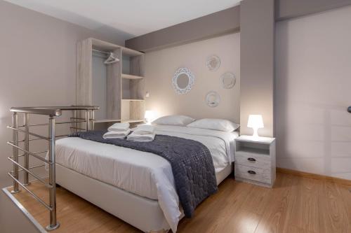 a bedroom with a large white bed and a night stand at Amaryllis Maison Hili in Alexandroupoli