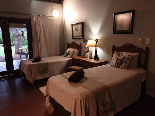 a hotel room with two beds and a window at Kruger Allo B&B in Komatipoort