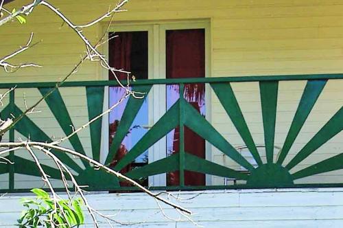 a green fence in front of a house at Charming Villa in Foulpointe with Sea View in Foulpointe