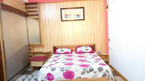 a bedroom with a bed with pink and purple pillows at Modern apartment with balcony and mountain view in Souillac in Souillac