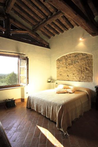 a bedroom with a bed and a large window at La Corte del Falco in Pieve a Nievole
