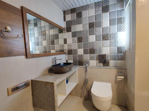 un bagno con un water e un lavandino di JenJon Karjat Resort - Hallelujah Villa a Karjat