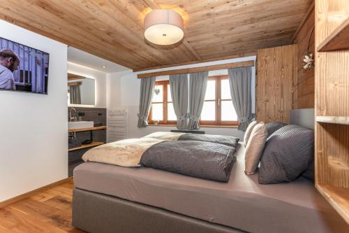 a bedroom with a large bed with a wooden ceiling at Bergchalet am Hochkönig in Mühlbach am Hochkönig