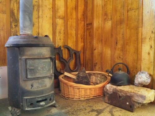 a stove and a basket with two cats in it at Portezuelo del Viento - Hostel de Montaña in Las Cuevas