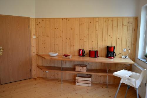 a room with a wooden wall with a counter and a kitchen at Ferienwohnung Klaus in Dolní Lánov