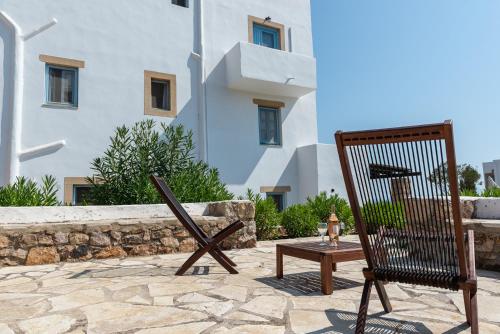 a wooden chair sitting on a patio next to a building at Patmos Studios in Skala