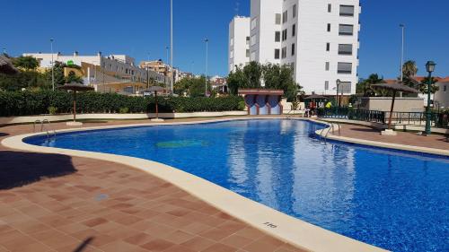 a large blue swimming pool in a city at Apartamento La Mezquita in Santa Pola
