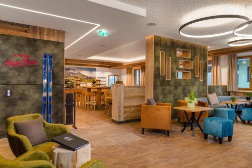 a lobby with chairs and tables and a restaurant at AlpenParks Hotel & Apartment Hochkönig in Mühlbach am Hochkönig