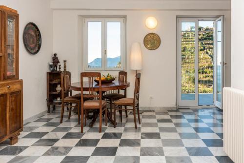 a dining room with a table and chairs on a checkered floor at Luxury Seaview Apartments Manarola by Arbaspàa in Manarola