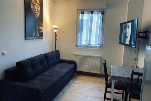 ein Wohnzimmer mit einer Couch und einem Tisch in der Unterkunft Comfortable new Apartment in #Koblenz# direkt am Rhein in Koblenz