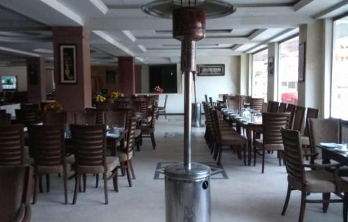 a dining room with tables and chairs in a restaurant at Millennium Inn Naran in Mānsehra