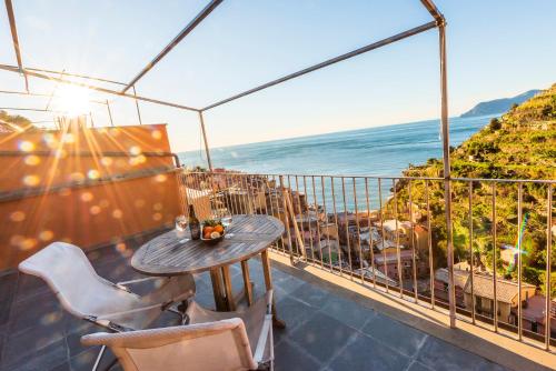 a table and chairs on a balcony with the ocean at Luxury Seaview Apartments Manarola by Arbaspàa in Manarola