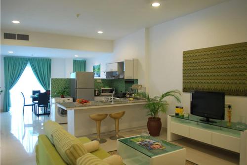 a living room with a couch and a kitchen at MCITI Suites in Miri