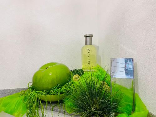 a bottle and a green plant and a glass at Limes Apartment -übernachten am Limes- in Rainau