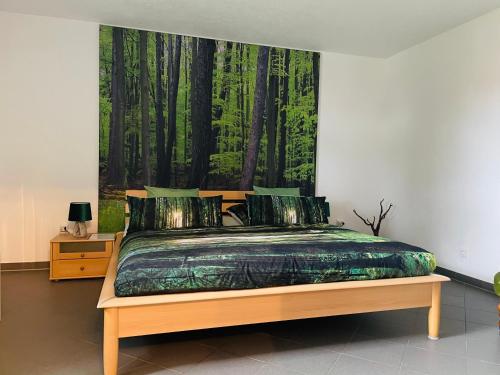 1 dormitorio con 1 cama con una pintura en la pared en Limes Apartment -übernachten am Limes- en Rainau