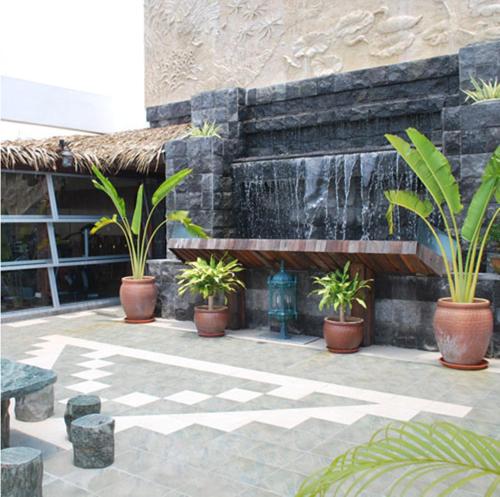 a courtyard with potted plants and a water fountain at MCITI Suites in Miri