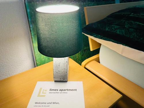 a lamp on a table with a sign on it at Limes Apartment -übernachten am Limes- in Rainau
