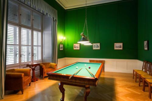 a pool table in a room with green walls at Károlyi Kastély Hotel & Restaurant in Fehérvárcsurgó