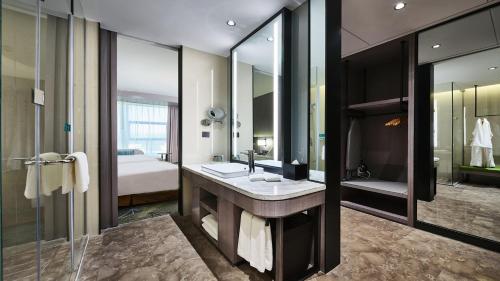 baño con lavabo y espejo grande en Holiday Inn Xining Hot-Spring, an IHG Hotel en Xining