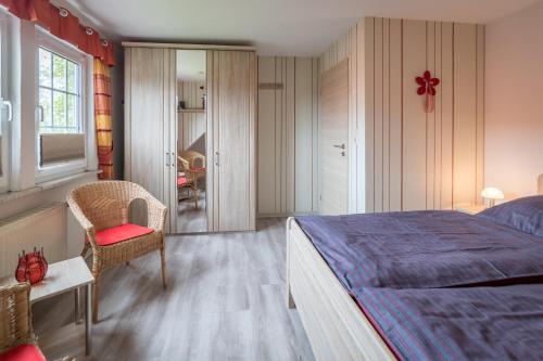 1 dormitorio con 1 cama, 1 silla y 1 ventana en Ferienwohnung Pieper, en Werdum